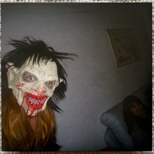 Vinyl record cover featuring a distorted, frightening face and blurry figures.