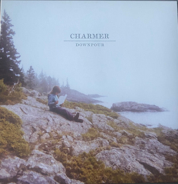 Vinyl album cover: a person reading by the sea in fog.