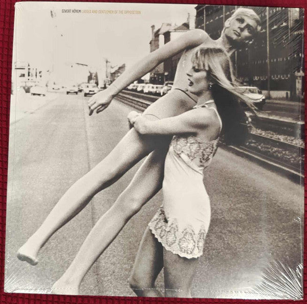 Vinyl record cover: two figures in white, blurred city background.