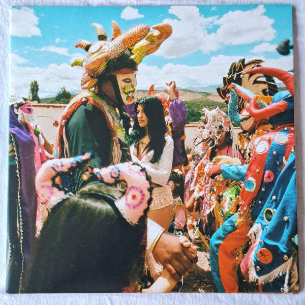 Vinyl album cover featuring a woman with performers in colorful masks.