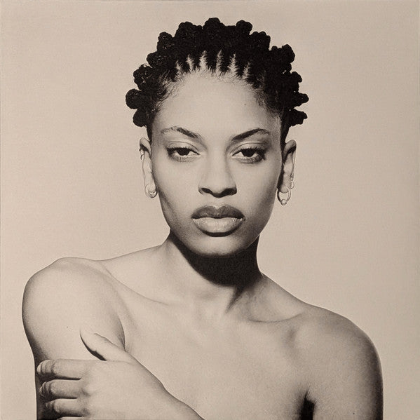 Black and white portrait of Annahstasia with braided hair, arms crossed.