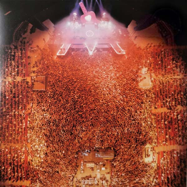 Overhead view of a large concert crowd with stage lighting.