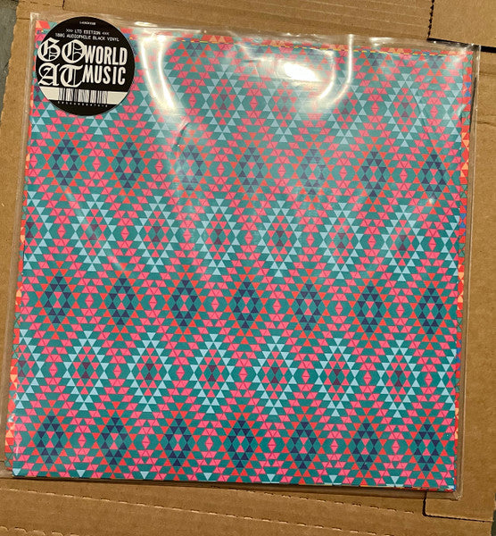 Vinyl record with a teal and red geometric patterned cover.