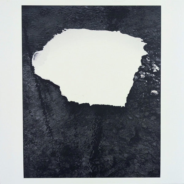 Black and white abstract album cover with a large white central shape.