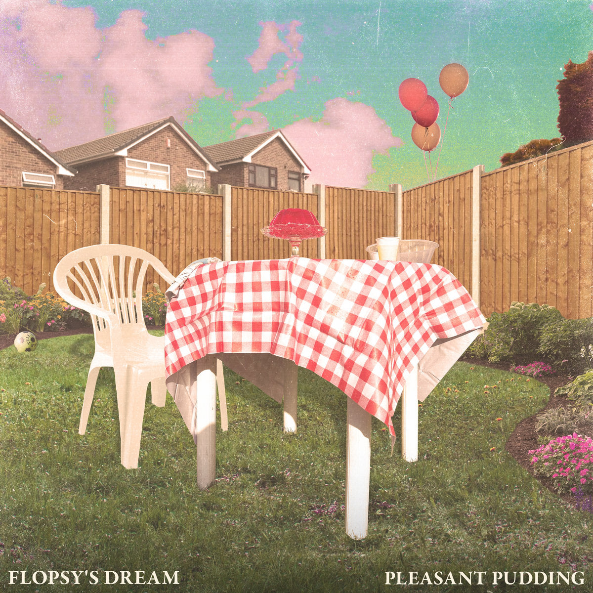 Backyard scene with a plastic table, red balloons, and houses.