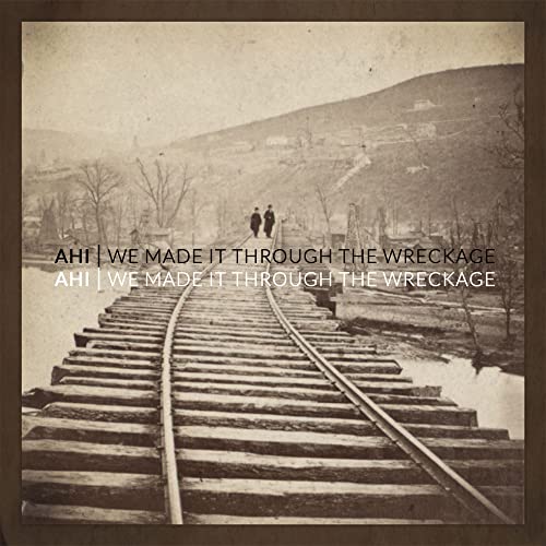 Album cover: railroad tracks leading to two figures in a landscape.