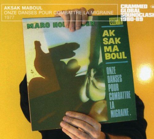 Person holding a green album cover with abstract shapes and yellow and white text.