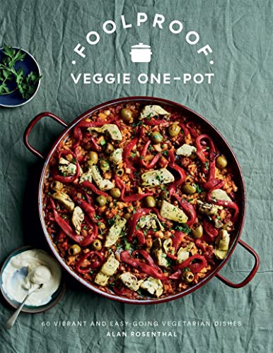 Cookbook cover featuring a large paella with vegetables and a small bowl of dip.