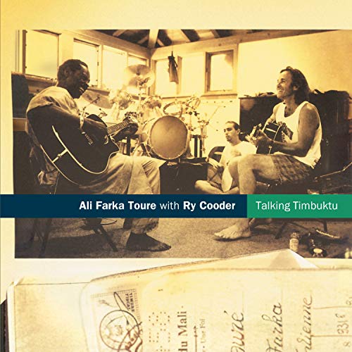 Ali Farka Touré and Ry Cooder playing guitars in a studio with a drummer.