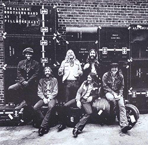 The Allman Brothers Band posing in front of shipping crates, 1971.