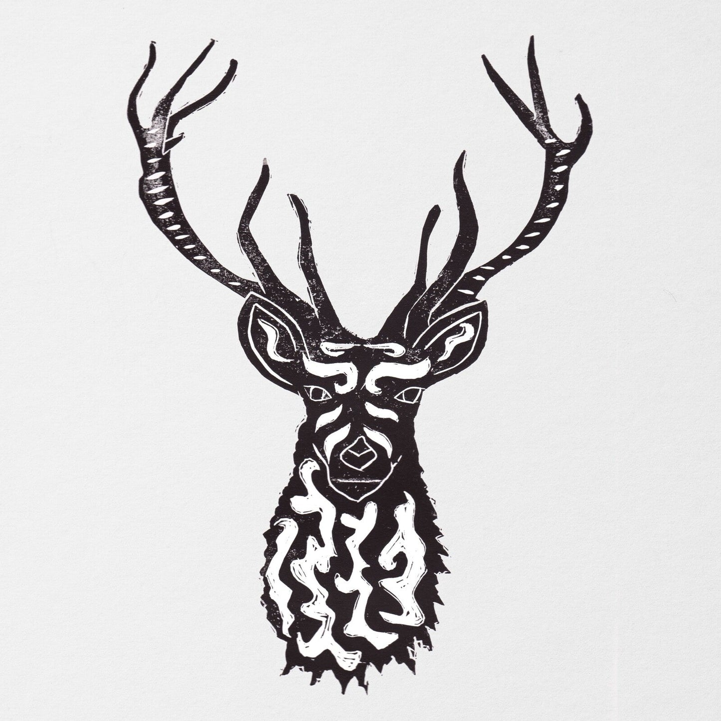 Black and white linocut print of a stylized deer head with intricate patterns.