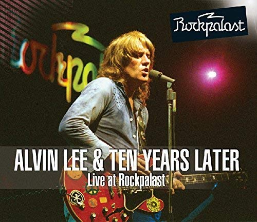 Alvin Lee performing live on stage with a red electric guitar and microphone.