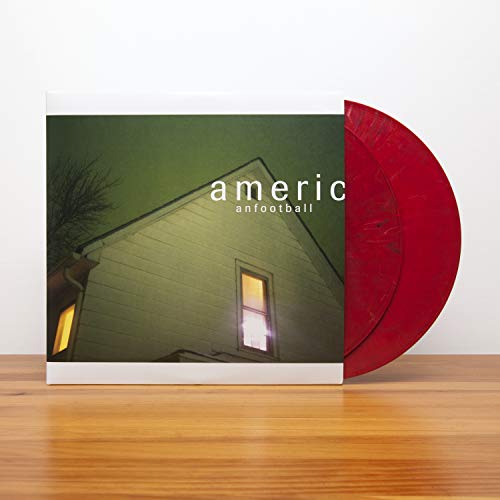 Vinyl record with red disc and album cover featuring a house.