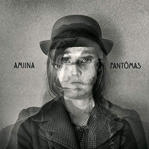 Black and white portrait of a person wearing a hat and coat.