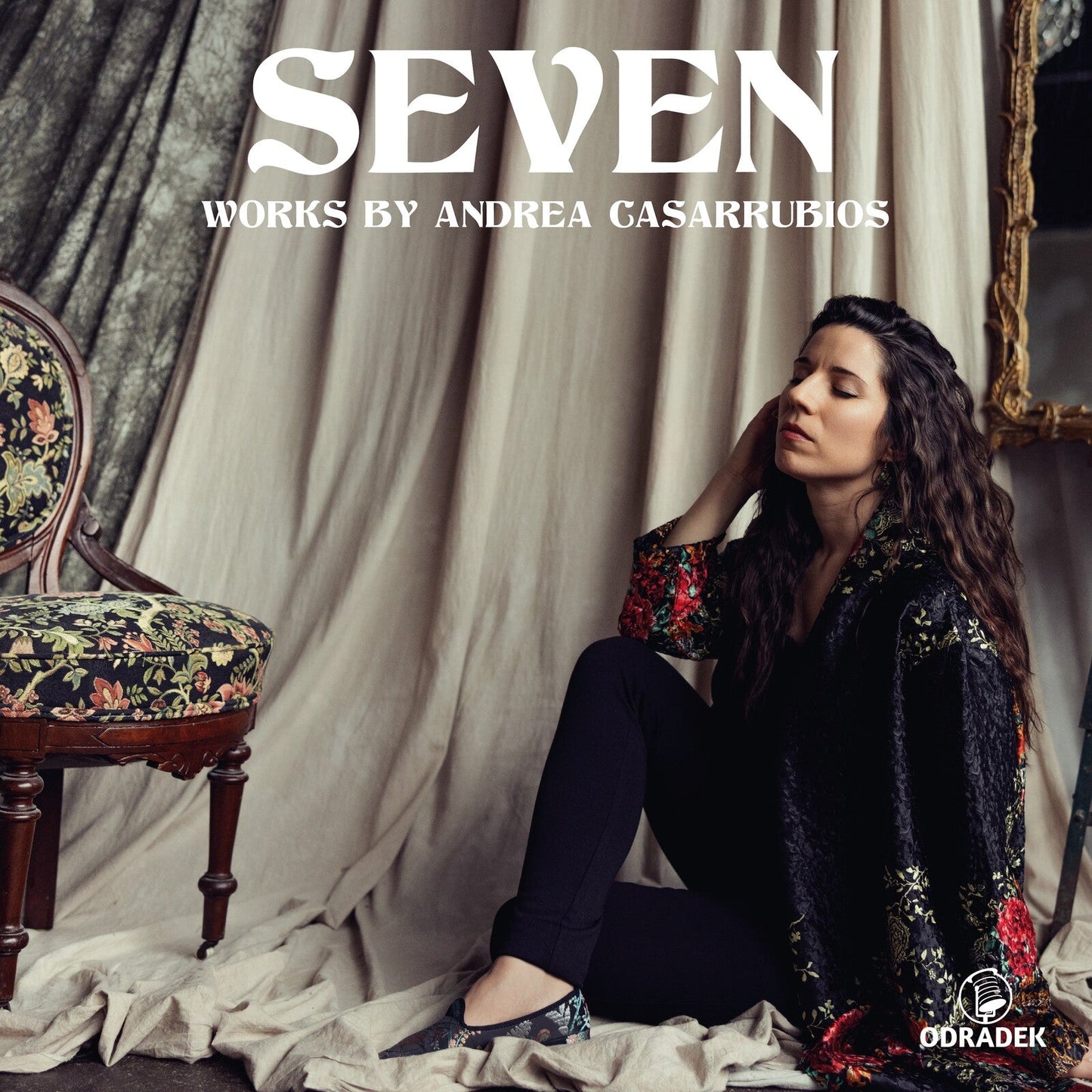 Album cover for "Seven" by Andrea Casarrubios, featuring a woman seated indoors.