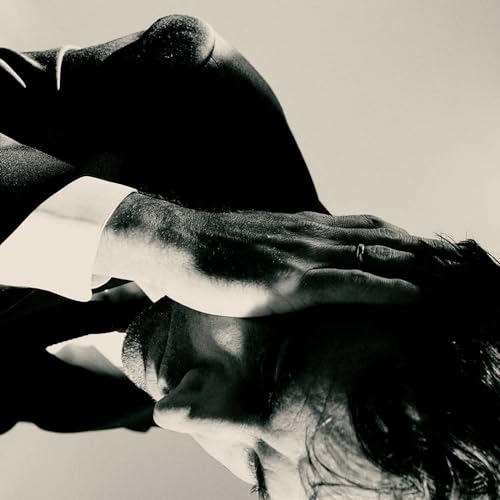 Black and white album cover featuring a person’s face and hands.