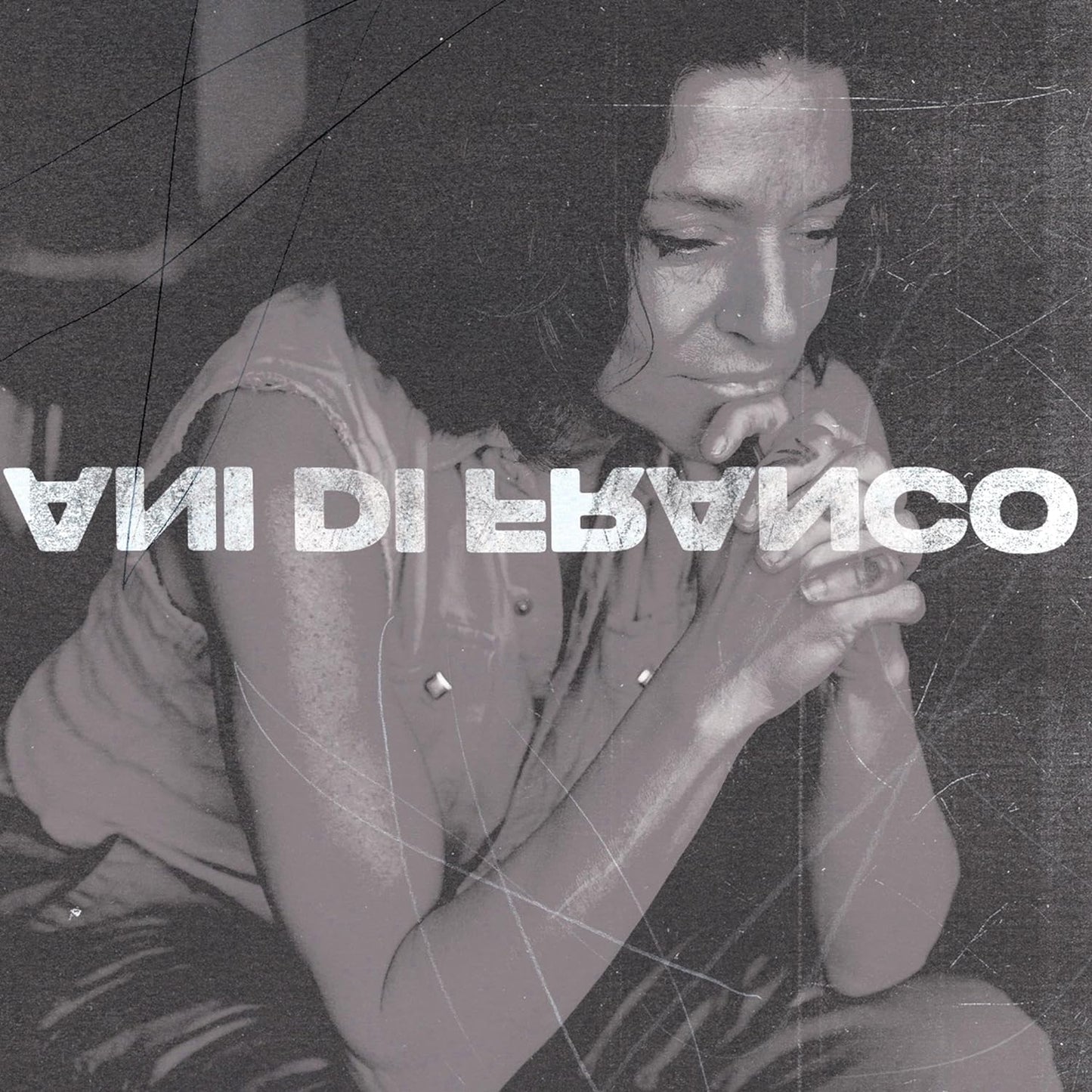 Black and white album cover featuring Ani DiFranco with hands clasped in contemplation.