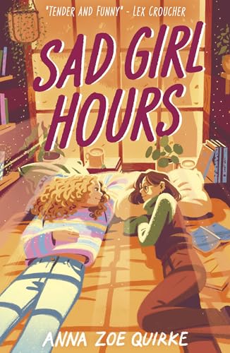 Two young women lie on a bed facing each other in a cozy room.
