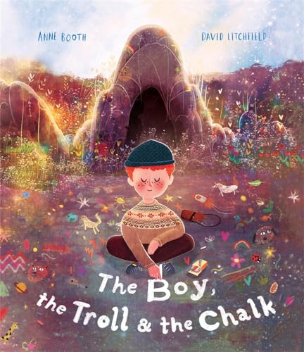 Boy with chalk sits before a dark cave and colorful landscape.