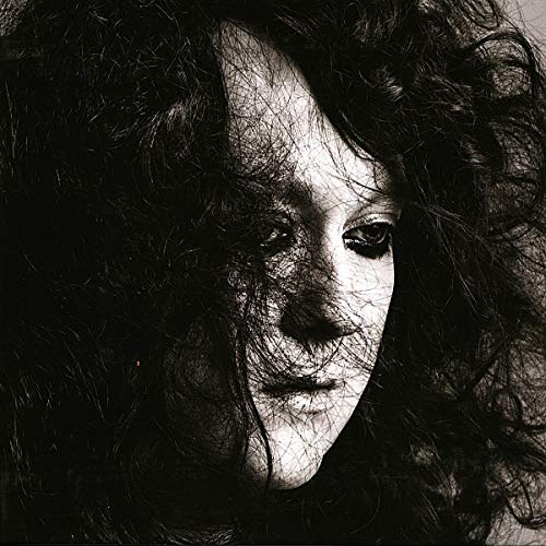 Black and white portrait of Anohni, with long, dark curly hair.