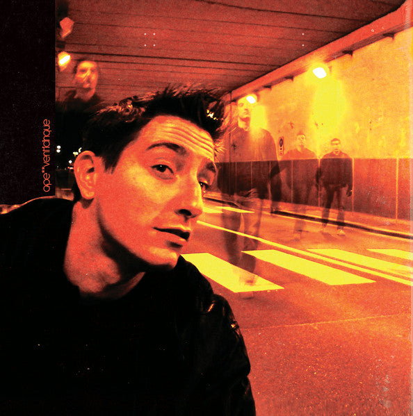 Vinyl album cover: man’s portrait with blurred figures in a tunnel.