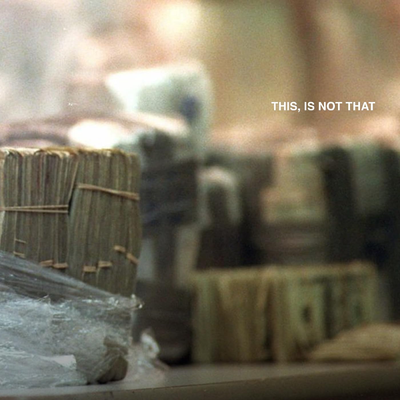 Blurred stacks of cash with text āTHIS, IS NOT THATā overlayed.