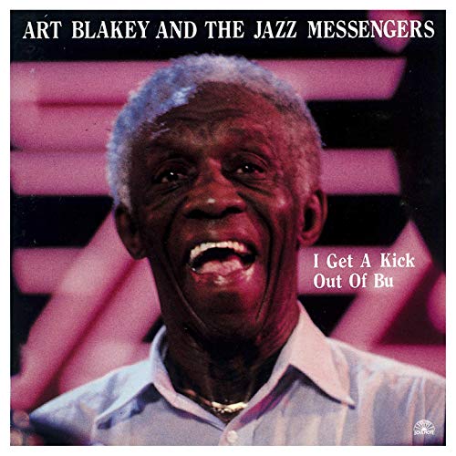 Art Blakey’s smiling face on a jazz album cover with pink geometric background.