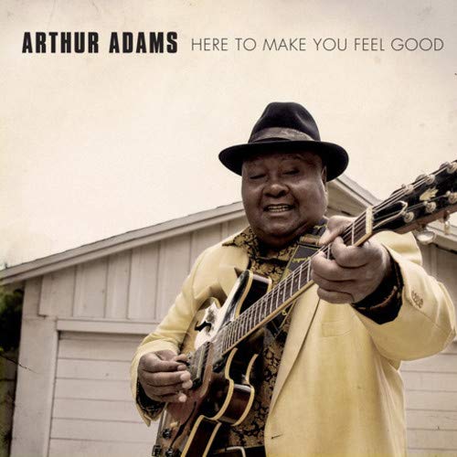 "Album cover featuring a man in a yellow suit playing guitar."