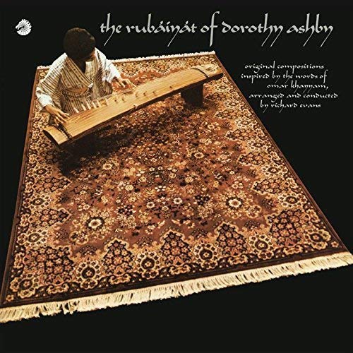 Dorothy Ashby playing a zither on an ornate red rug.