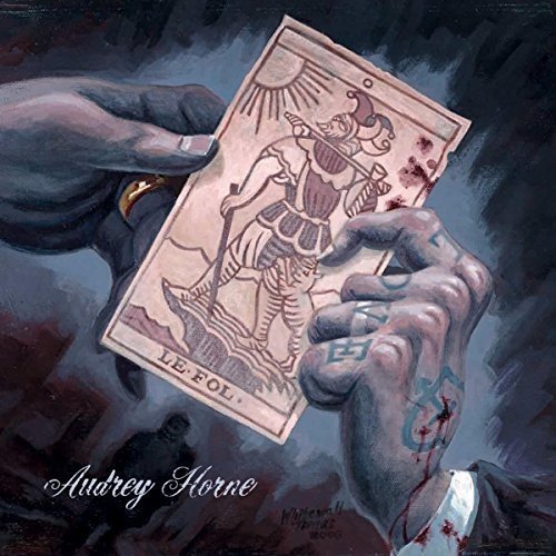 Painted album cover featuring hands holding a tarot card, “Le Fol.”