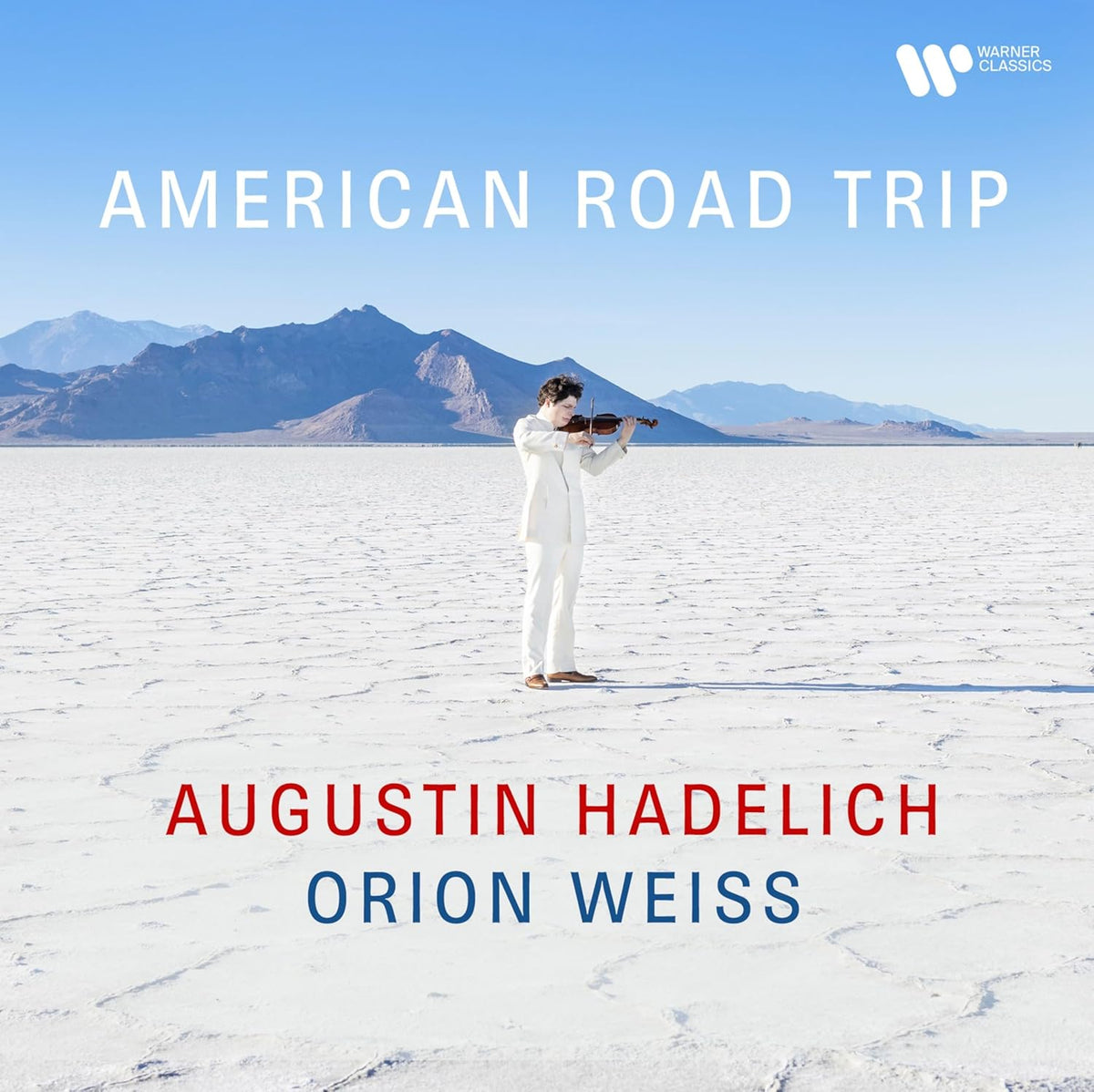 Violinist Augustin Hadelich stands on a vast, white desert landscape.