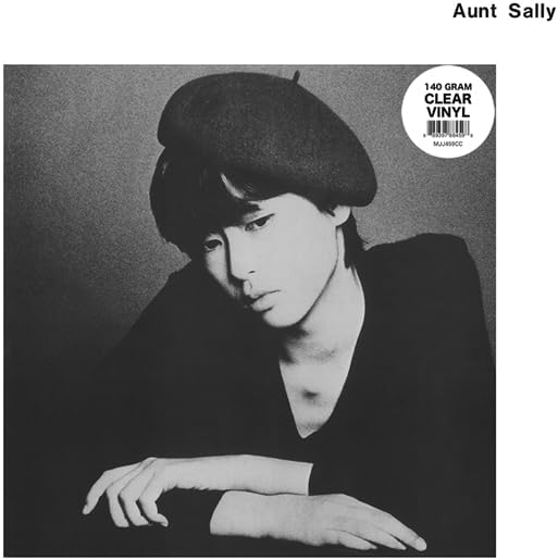 Black and white portrait of a person wearing a beret, vinyl record.