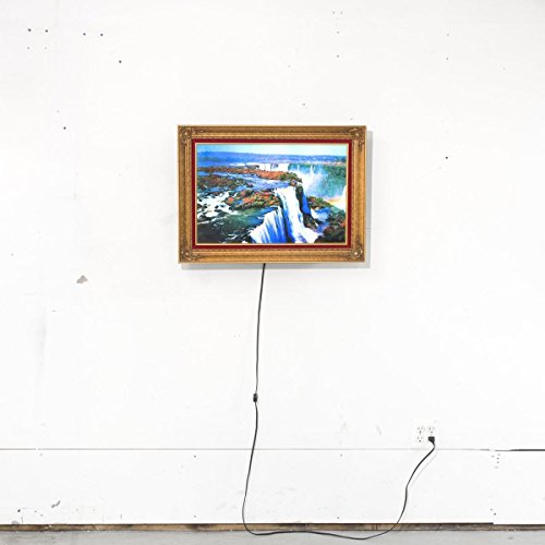 Framed painting of a waterfall hangs on a white wall with a cord.
