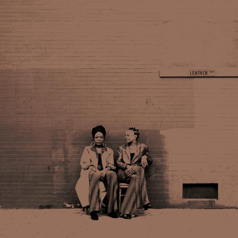 CD cover: Two women seated against a brick wall, sepia tone.