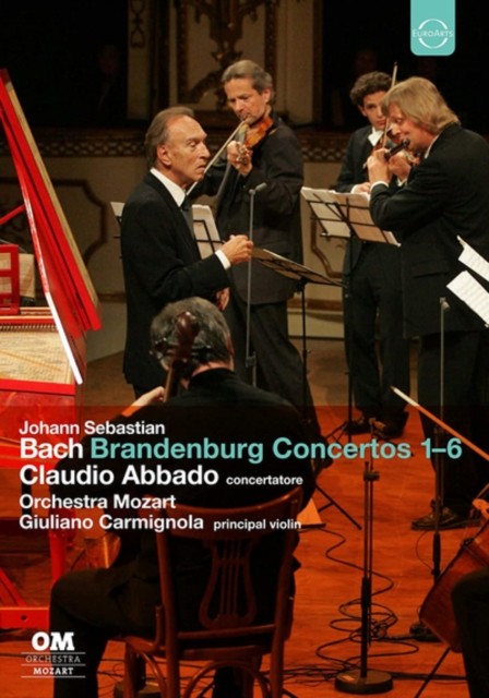 DVDCello player in foreground facing an orchestra and conductor performingS performing Bach's concertos.