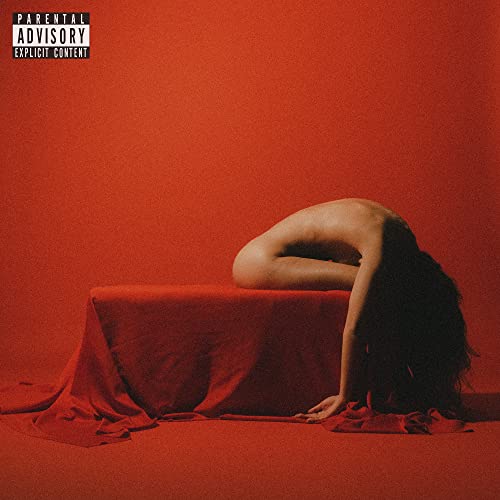 Red album cover featuring a person with long hair lying on a table.