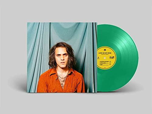 Green vinyl record with album cover featuring a man in orange.