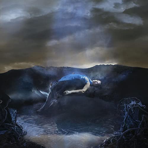Person lying in water against a dark, stormy sky background.
