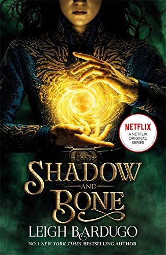 Book cover: woman with glowing hands, title “Shadow and Bone” visible.