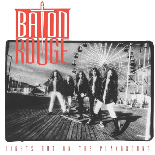 Band members stand on a boardwalk in front of a Ferris wheel, black and white.