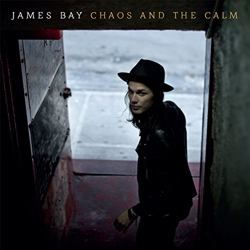 James Bay album cover: artist in hat, doorway, dark and moody.