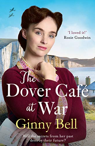 A woman in a maroon cardigan stands before the white cliffs of Dover.