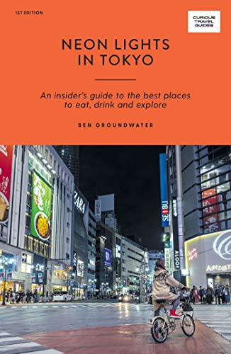 Travel guide cover featuring a Tokyo street scene with bright neon lights.