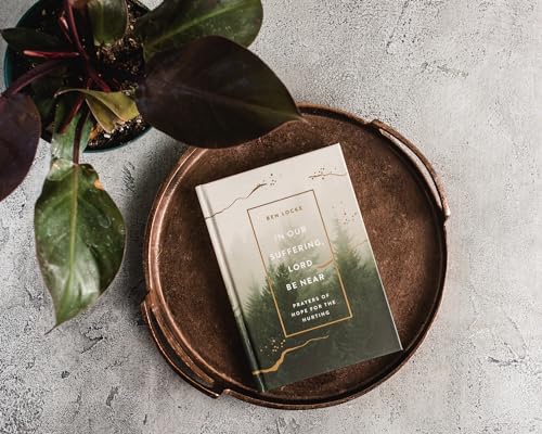 Book titled “In Our Suffering, Lord Be Near” on a metal tray.