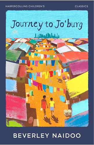 Two children walk through a colorful shantytown with laundry hanging on lines above them.