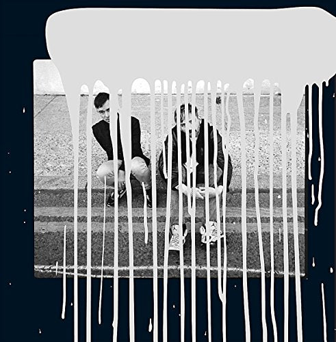 Black and white photo of two people on steps, with white paint drips.