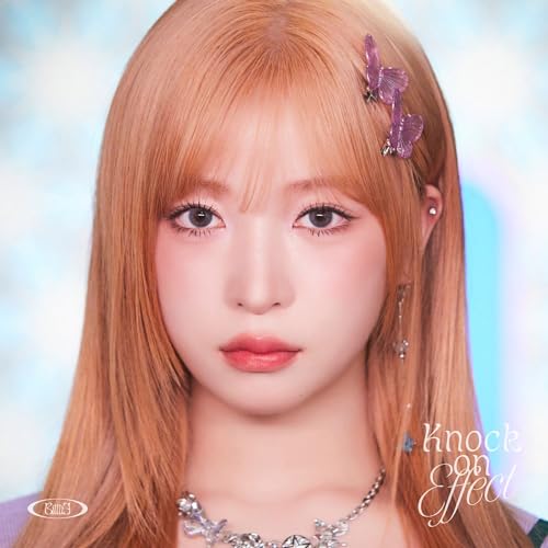 Close-up of a young woman with long orange hair and butterfly hair clips.