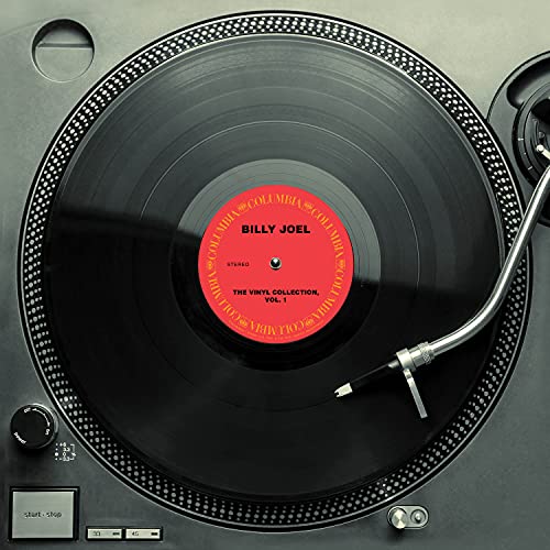 Billy Joel vinyl record on a black turntable, red label visible.