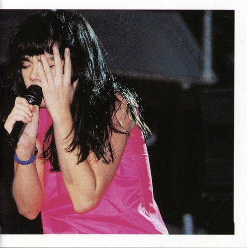 "Album cover featuring a woman in pink singing into a microphone."