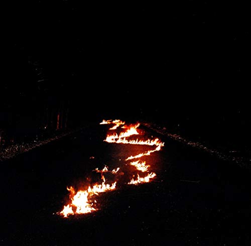 Dark road with bright orange flames burning across the asphalt.